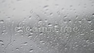 玻璃上的水滴特写，雨，走开。 夏季淋浴时，大的雨滴撞击窗户玻璃。